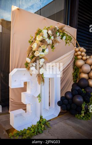 Circle wall decoration with golden balloons and the numbers 30 for a woman's thirtieth birthday celebration. High quality photo Stock Photo