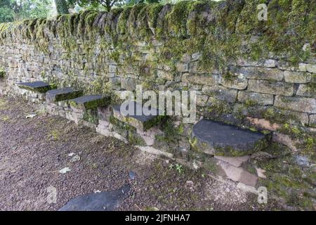 Example of field stone wall with some seats, part of a dry stone walling exhibit, Shibden Park, Halifax, Yorkshire, UK. Stock Photo