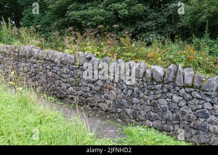 Example of a random limestone (black and white*) wall, part of a dry stone walling exhibit, Shibden Park, Halifax, Yorkshire, UK. Stock Photo