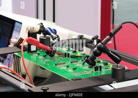 Chip testing equipment. A close-up study of a test sample of a transistor chip under a microscope in the laboratory. Automation of production. Stock Photo