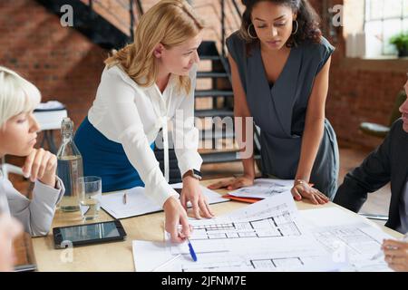 We need this completed first before we proceed. Shot of a group of architects working with blueprints in an office. Stock Photo