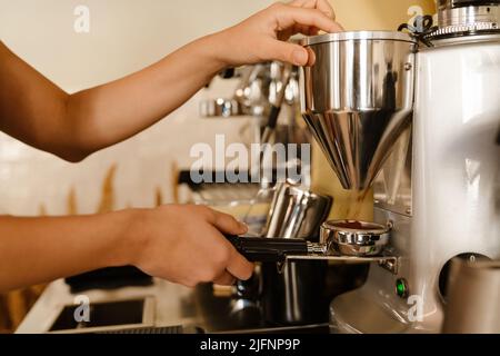 Young barista making coffee while working in cafe Stock Photo