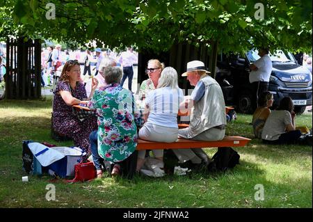 Surrey, UK, 04/07/2022,Visitors relax by the Long Water. RHS Hampton Court Palace Garden Festival, East Molesey. Stock Photo