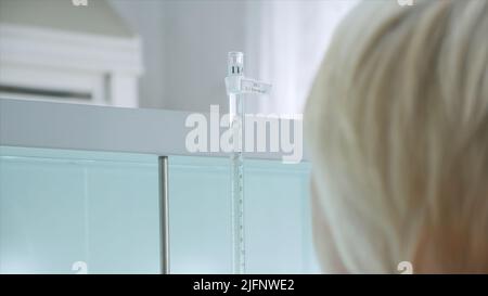 Woman conducts laboratory experiments and analyzes. Clip. Woman looks at chemical liquid in laboratory. Industrial laboratory with workers and Stock Photo