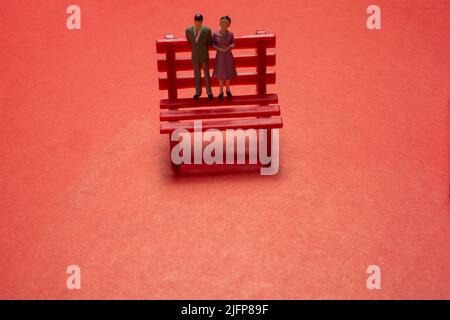 View of a man and a woman standing on a bench., symbolic photo with miniature figurines Stock Photo