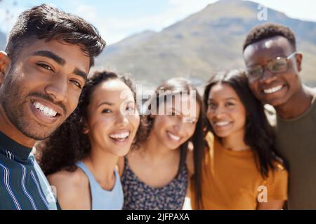 Friends become our chosen family. Portrait of a group of young friends hanging out together outdoors. Stock Photo