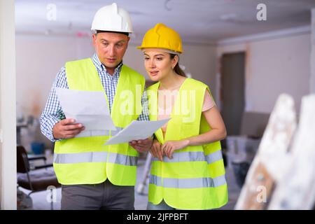 Man and woman builders talking in house Stock Photo