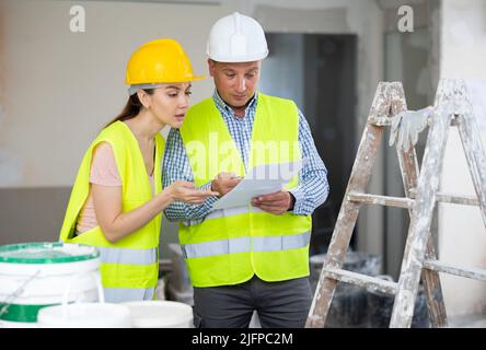 Man and woman builders talking in house Stock Photo