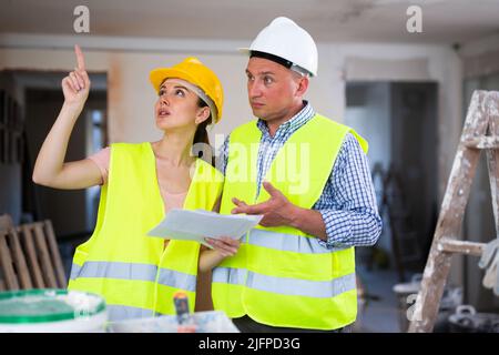 Woman and man repairers talking about documentation Stock Photo