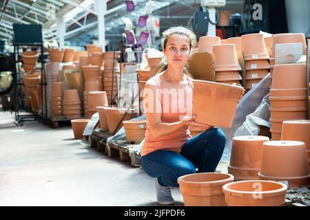 Female seller is standing near clay pots in stock Stock Photo