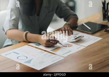 Close up Business woman hand using calculator to calculate the company's financial results and budget. Account Audit Concept. Stock Photo
