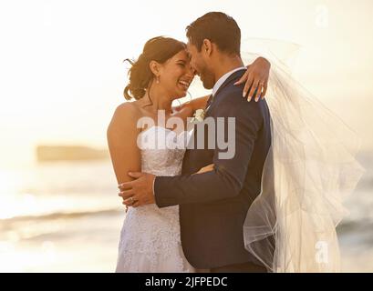 Ill stand by your side in the good and the bad. Shot of a young couple on the beach on their wedding day. Stock Photo