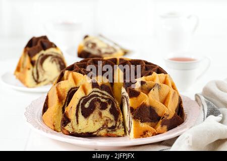 Sliced of Bundt Marble Cake on White Table. Copy Space for Text or Advertisement Stock Photo