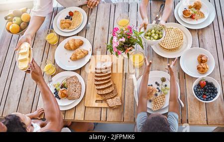 Food and family. Shot of an unrecognizable family having lunch at home. Stock Photo