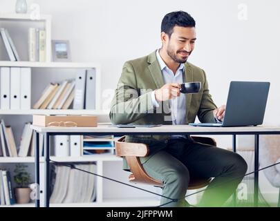 Ita a good day to do business. Cropped shot of a handsome young businessman working at his desk in the office. Stock Photo