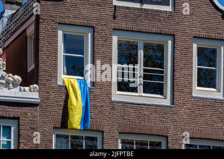 Ukraine flag hanging from a window in Amsterdam, Netherlands Stock Photo