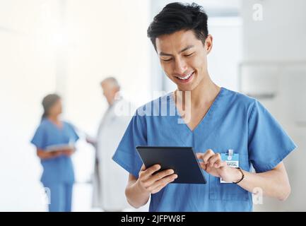 Getting loads more done in digital format. Shot of a young doctor using a digital tablet in a hospital. Stock Photo