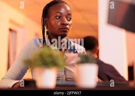 Confident female freelancer analyzing research data on computer at office job, working with executive information to create email report for manager. Looking at management paperwork on pc. Stock Photo