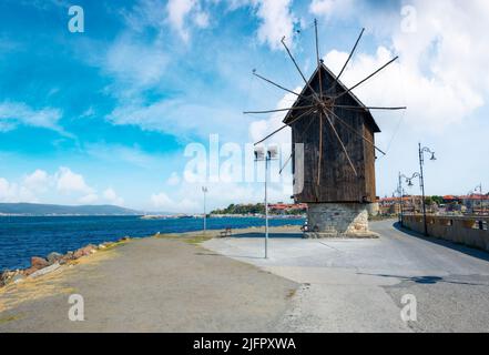 nessebar, bulgaria - sep 2, 2019: old windmill on the embankment at the sea shore. popular travel destination. sunny weather in velvet season Stock Photo