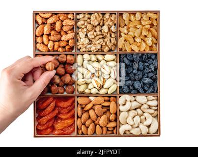 Hand with assorted nuts and dried fruit collection. Assorted nuts almonds, pistachio, cashews, walnut. Organic mixed nuts background. Healthy food, Us Stock Photo