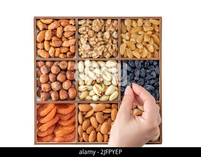 Hand with assorted nuts and dried fruit collection. Assorted nuts almonds, pistachio, cashews, walnut. Organic mixed nuts background. Healthy food, Us Stock Photo