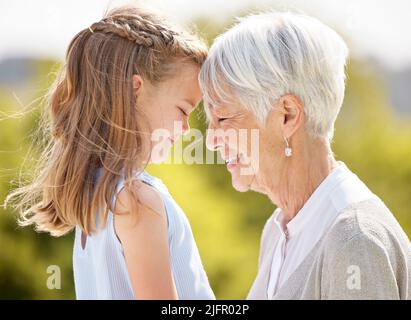 We as parents are their most important role models. Shot of an elderly woman spending time outdoors with her granddaughter. Stock Photo