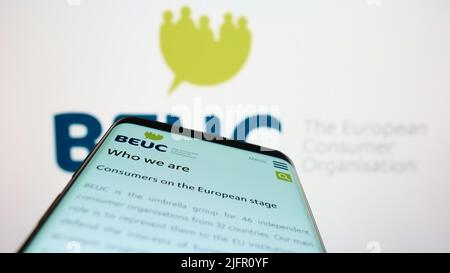 Mobile phone with website of Bureau Europeen des Unions de Consommateurs (BEUC) on screen in front of logo. Focus on top-left of phone display. Stock Photo