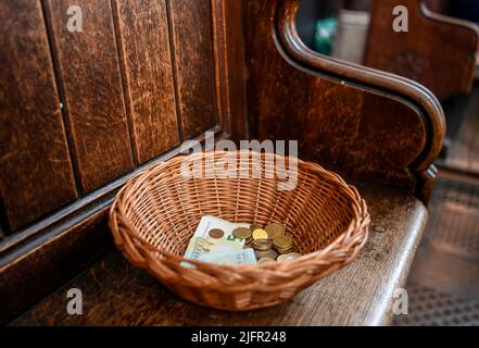 Money is placed in a collection basket during Sunday Mass in Catholic ...