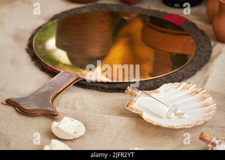 Ancient Roman mirror, retro perfume and vintage bath accessories. Reconstruction of events in the thermae of the Roman Empire Stock Photo