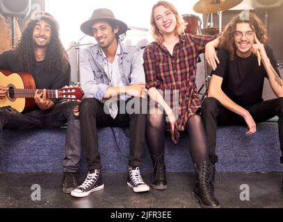Were here to entertain you. Full length portrait of a band sitting on stage before their gig. Stock Photo