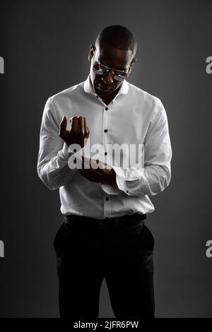 Feeling funky fresh and fly. Shot of an attractive man getting dressed against a studio background. Stock Photo