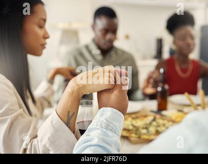 Were grateful for this moment. Shot of a group of friends saying grace before eating a meal together. Stock Photo