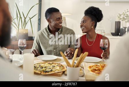 We keep thing classy with our pizza dates. Shot of an affectionate couple sitting together at a dining table. Stock Photo