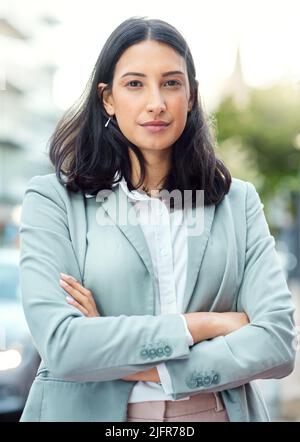 Work it like you mean it. Portrait of a confident young businesswoman standing against an urban background. Stock Photo