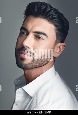 Confidence is always in vogue. Studio shot of a handsome young man posing against a grey studio background. Stock Photo