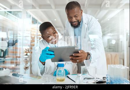 Dive into our world of science. Shot of two scientists using a digital tablet in a laboratory. Stock Photo