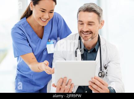 Early morning discussions with the doctors. Shot of two doctors using a tablet in a office. Stock Photo