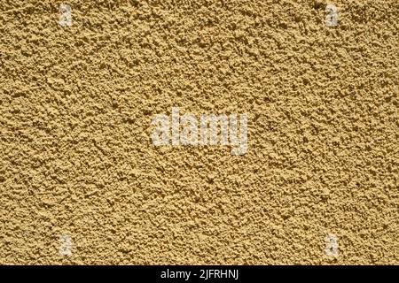 Plastered house wall facade surface dyed in shade of beige closeup as background Stock Photo