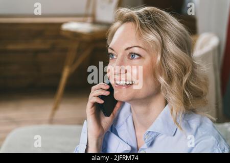 Beautiful woman is talking on the phone and smiling.  Stock Photo