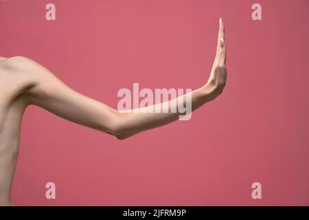 Young woman's stretched skinny arm thumb up. Isolated on pink background  Stock Photo - Alamy