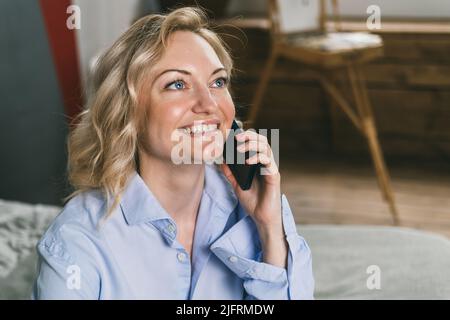 Beautiful woman is talking on the phone and smiling. Stock Photo