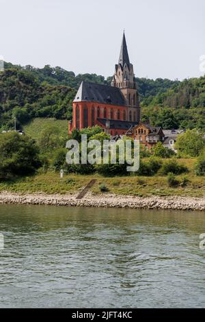 View of Gothic Liebfrauenkirche (Church of Our Lady) along the upper middle Rhine River in Oberwesel, Germany. Also called The Red Church. Stock Photo