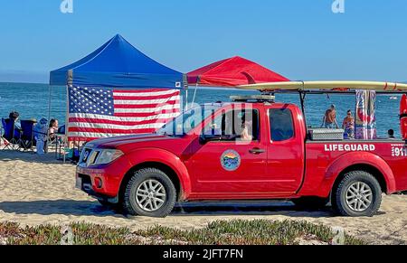 Santa Barbara, California, USA. 4th July, 2022. Red Lifeguard truck drives past an American flag on a picnic tent at East Beach, in Santa Barbara California, USA, on a sunny July 4th Holiday at the Pacific Ocean. (Credit Image: © Amy Katz/ZUMA Press Wire) Stock Photo