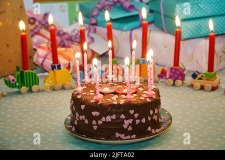 Birthday cake for the anniversary. Candles on the cake. Chocolate cake to celebrate. Children's birthday, party and cake for it. Stock Photo