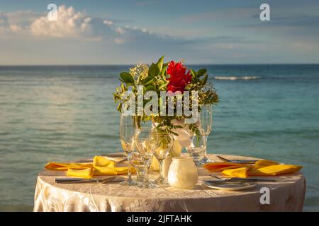 Romantic dinner: table for two and Beach with bouquet Montego Bay - Jamaica Stock Photo