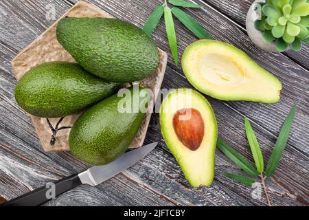 sliced avocado on wood background top view Stock Photo