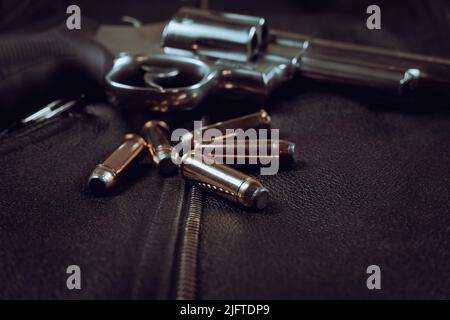 .44 magnum revolver and ammunition on a black leather background biker jacket Stock Photo