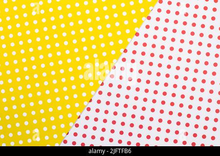 A yellow and white paper background with white and red polka dots Stock Photo