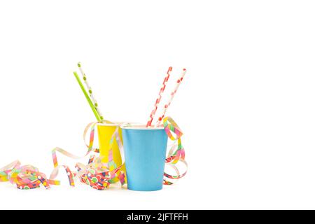 Colored drinking straws in yellow and light blue paper glasses on a white background Stock Photo