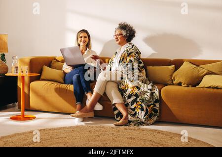 Two happy businesswomen having an online meeting in an office lobby. Successful female entrepreneurs having a video call with their business partners Stock Photo